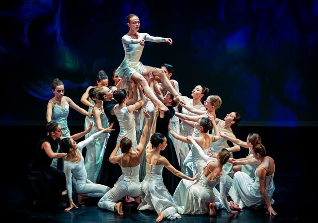 Ensemble de danseuses en blanc sur scène